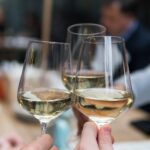 Brindisi con calici di vino bianco – consumo sociale e target internazionale